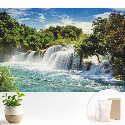 Tapeta s motivem vodopádu v zelené krajině při západu slunce